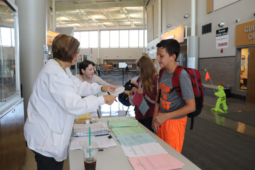 Students at Nurse's table getting forms