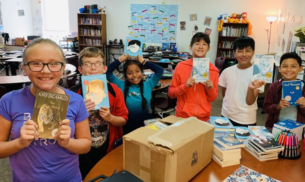students showing off their new books